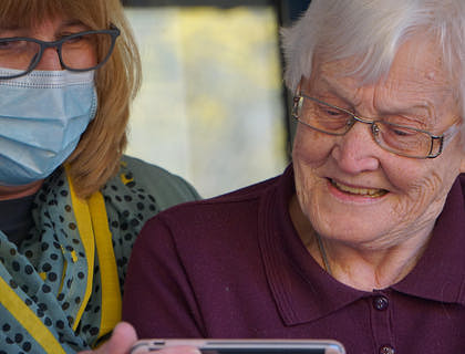 Um humilde cuidador ajudando uma mulher idosa.