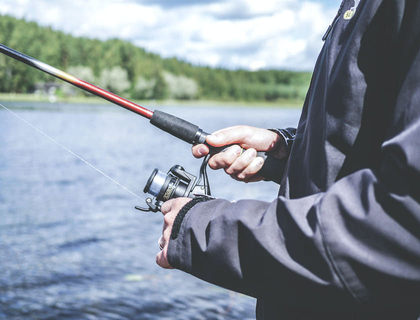 Una persona che pesca con articoli comprati in un negozio di caccia e pesca.