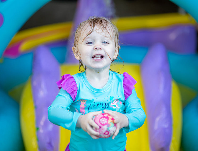 Menina segurando uma brinquedo em um parque indoor.