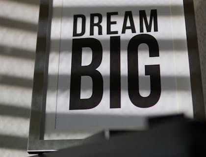 Un póster con una frase inspiradora colgado en la pared de una oficina en un negocio inspirador.
