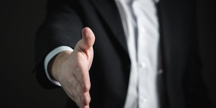 Man in suit with hand stretched out for a handshake