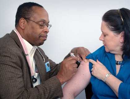 Médico aplicando injeção em uma paciente em uma clínica médica.