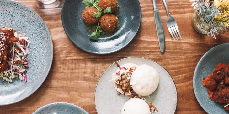 Four plates of various dishes inspired by regions across the globe.