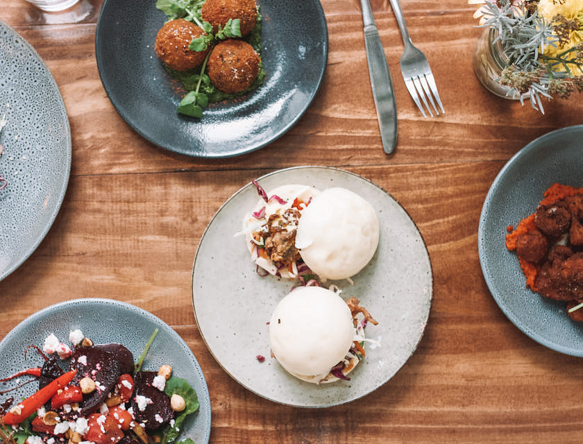 Four plates of various dishes inspired by regions across the globe.