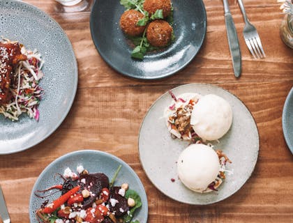 Four plates of various dishes inspired by regions across the globe.