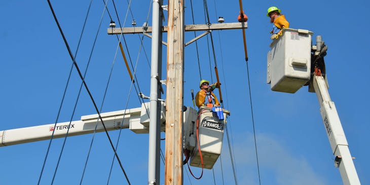 Un fournisseur de services Internet monteur de lignes mettant des câbles Internet sur un poteau électrique.
