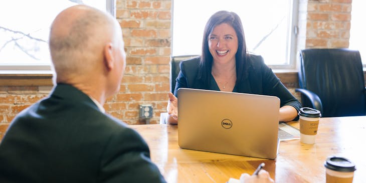 Two people sitting at a table talking.