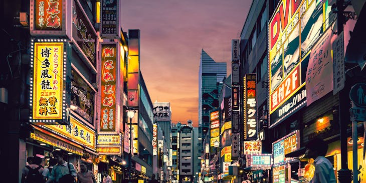 Gente caminando en las calles de Tokio, en Japón, frente a negocios de comida japonesa.