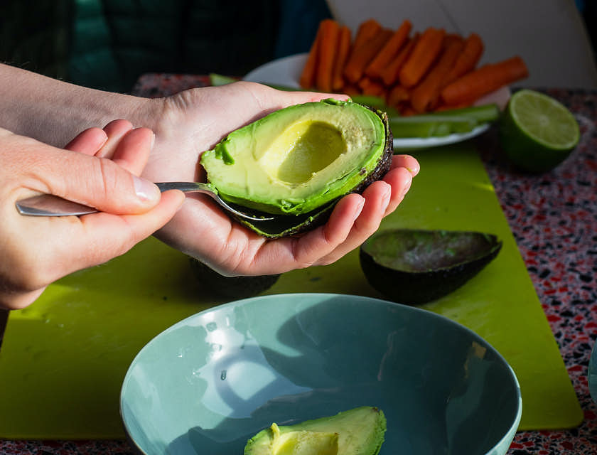 Une personne coupe un avocat dans le cadre de son régime keto.