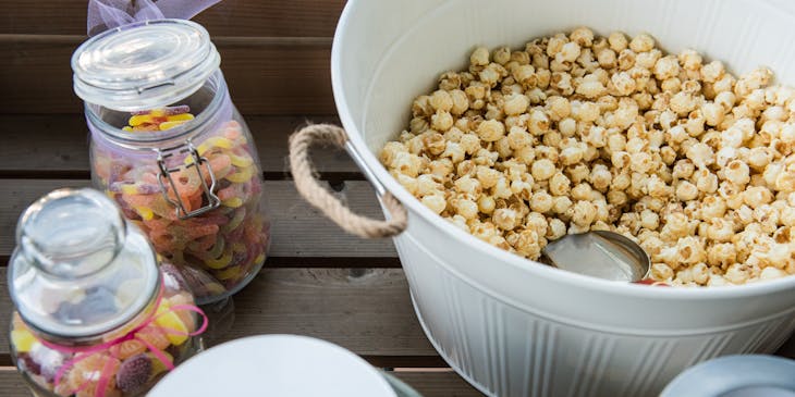 scoop in white bucket filled with kettle corn