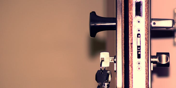 A bunch of keys hanging in a door at a key & locksmith business.