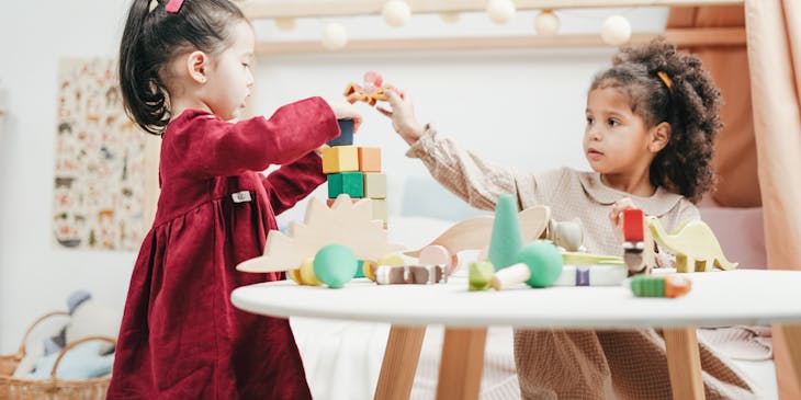 Two girls playing with blocks at a kid business.