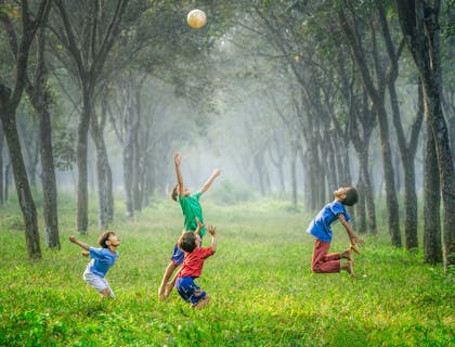 Kids playing with a ball outside.