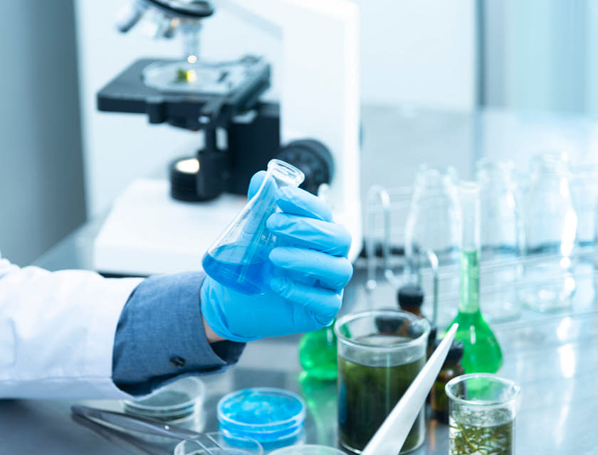 Laboratorista sosteniendo un matraz en un laboratorio.