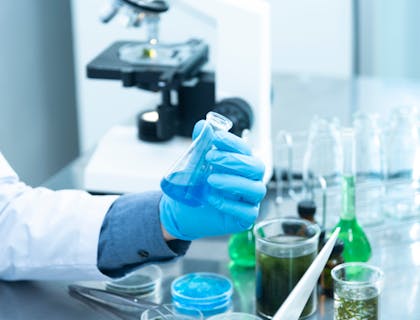 Person holding a flask in a lab business