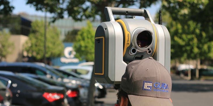 Man looking through land surveying device.