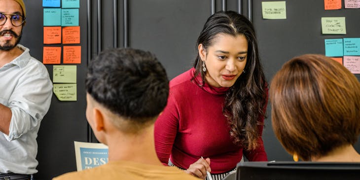 A woman in a red sweater speaking a language.