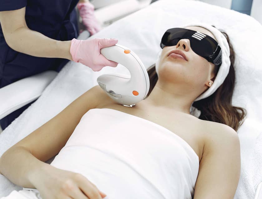 Mulher em uma clínica de depilação a laser fazendo procedimento estético.