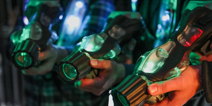 People holding green and black laser tag guns.