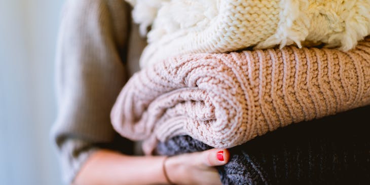 A laundry service worker holding freshly folded clothes.