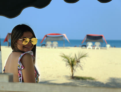 Una donna sorridente in spiaggia che si gode un momento di svago.
