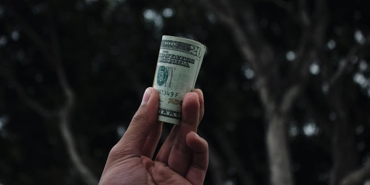 A person holding a roll of money.