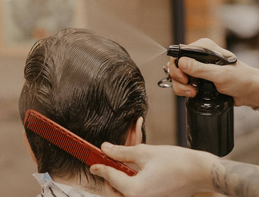 Une personne se fait pulvériser du liquide sur les cheveux dans une entreprise de traitement des poux.