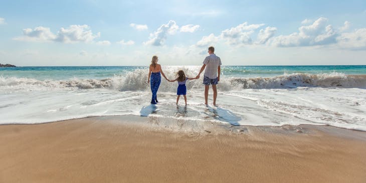 A man, a woman, and a child enjoying the seashore after taking out life insurance.
