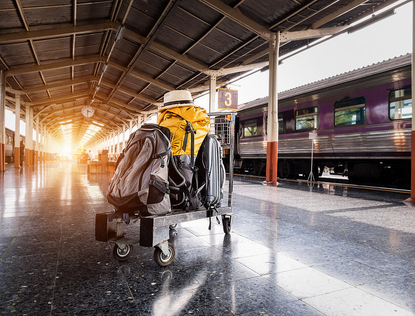 Plusieurs bagages sur un chariot dans une gare.