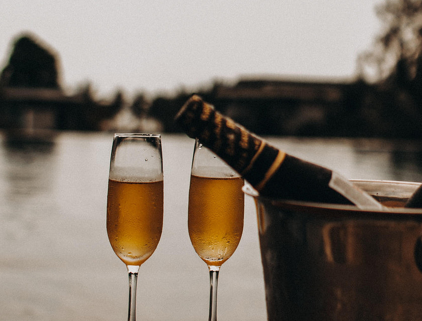Duas taças de champanhe, um balde de gelo e uma garrafa de champanhe em uma empresa de luxo.