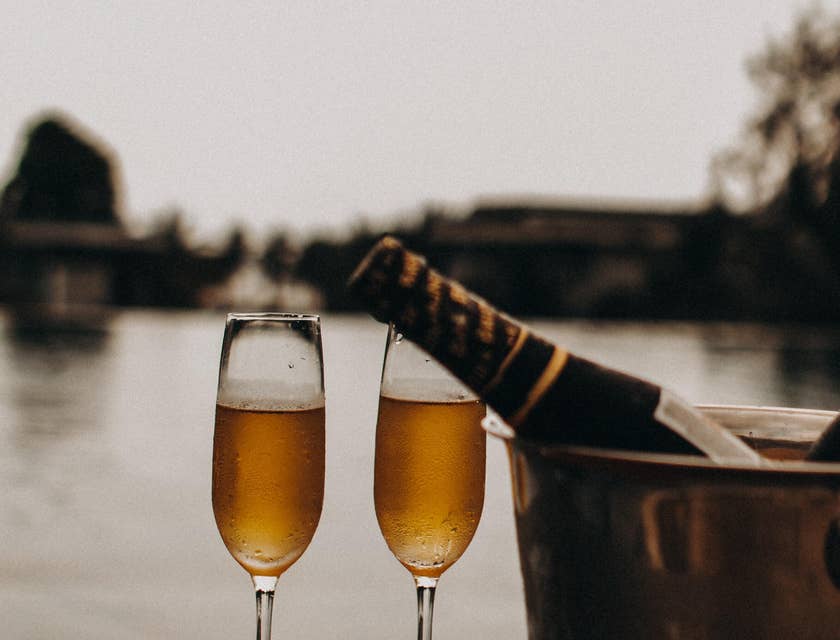 Two champagne glasses, an ice bucket, and a bottle of champagne provided by a luxury business.
