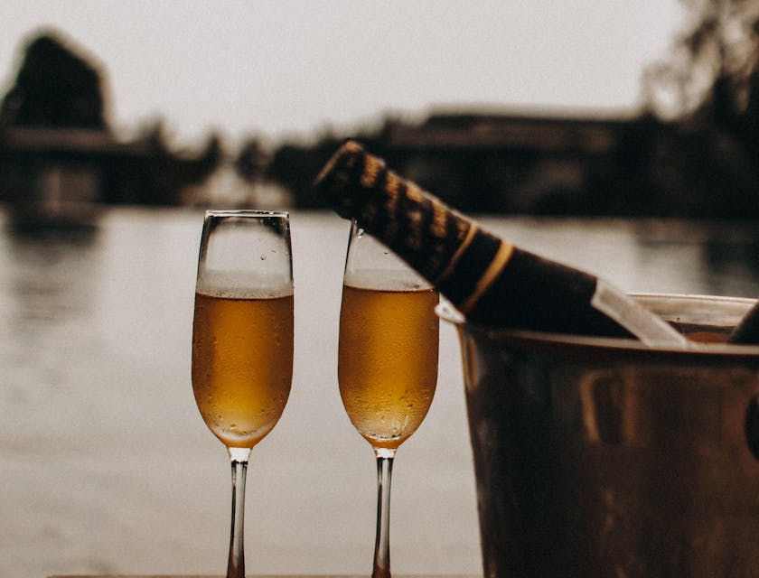 Two champagne glasses, an ice bucket, and a bottle of champagne provided by a luxury business.