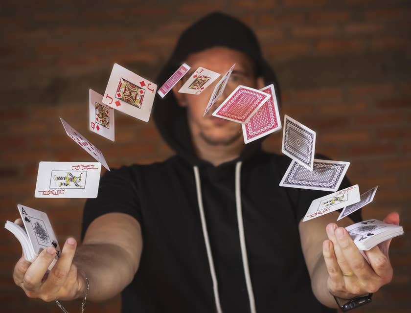Un magicien travaillant dans un magasin de magie et jetant des cartes à jouer en l'air.