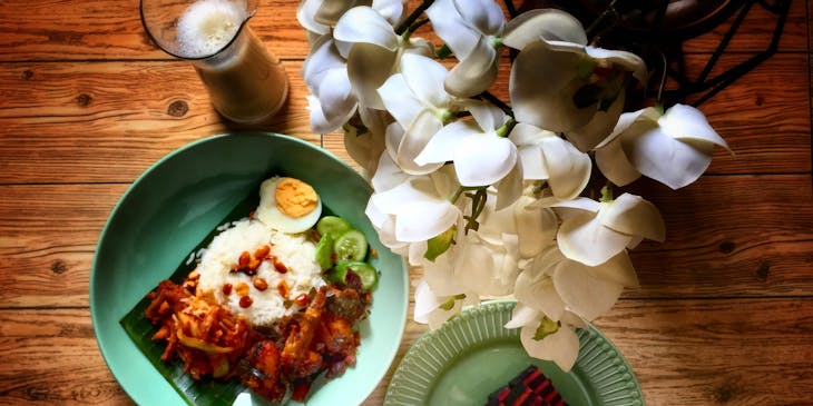 Malaysian food dishes on a wood table.