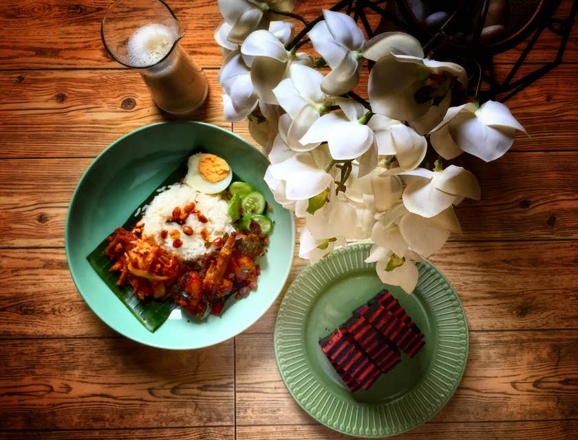 Pratos da culinária da Malásia em uma mesa de madeira.