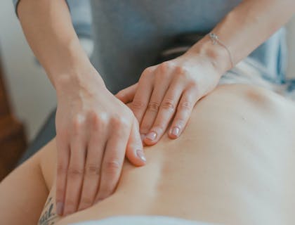 Un terapeuta de masaje con un paciente en una escuela de masajes.
