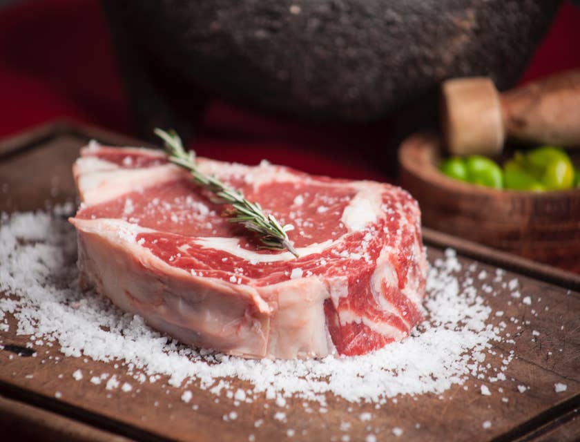 Un gran corte de carne con romero y sal en una carnicería.