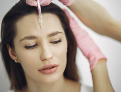 Una mujer siendo inyectada con botox en un spa médico.