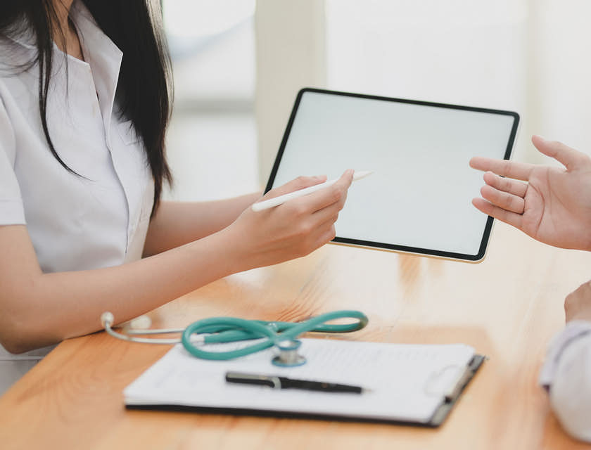 woman sitting with a stethoscope and tablet