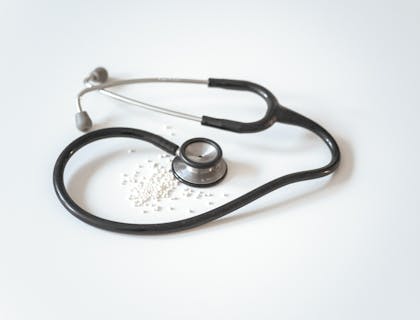 Uno stetoscopio poggiato sopra la scrivania dello studio di un medico.