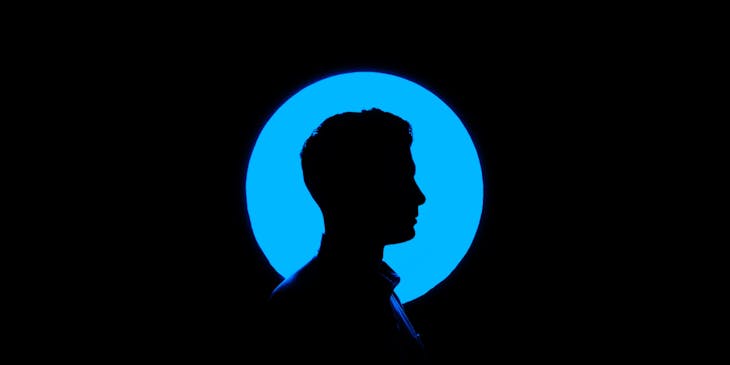 silhouette of man in front of blue light
