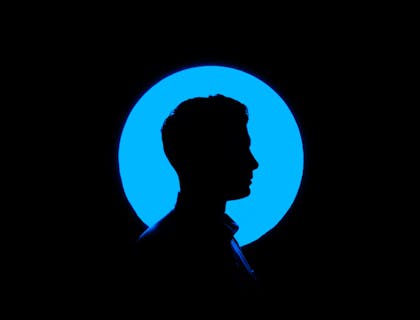 silhouette of man in front of blue light