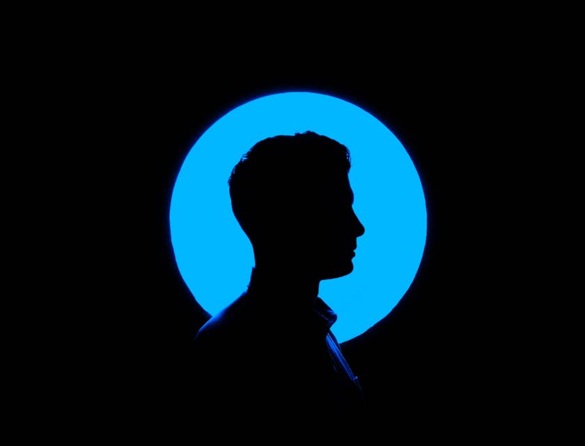 Il profilo di un uomo di fronte a una luce blu.
