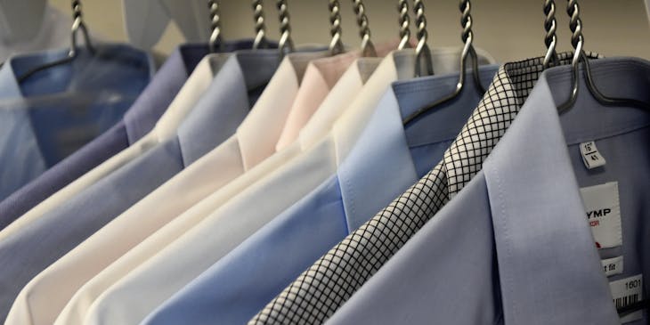 Formal men's shirts on hangers at a men's clothing business.