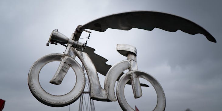 A metal bicycle made by metal art business display in an outside area.