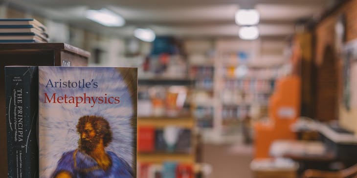 A book with the words Aristotle's Metaphysics displayed in a metaphysical bookstore.