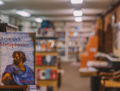 A book with the words Aristotle's Metaphysics displayed in a metaphysical bookstore.