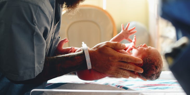 Midwife holding a newborn baby.