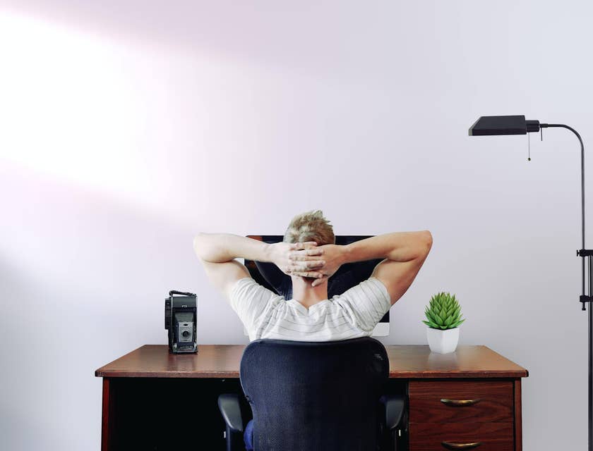 Un uomo seduto alla scrivania di uno studio in un'azienda dallo stile minimale.