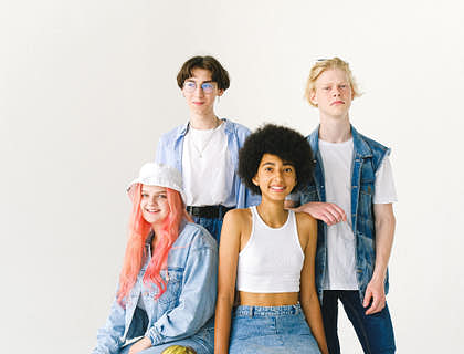 A group of female and male models smiling and posing during a photoshoot.